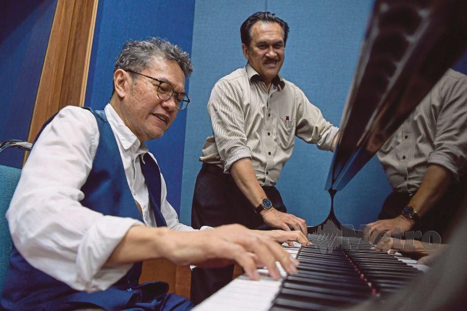 WAH (kiri) memainkan piano sambil diperhatikan Mokhzani pada sesi temu bual eksklusif sempena Ulang Tahun Rukun Negara ke-50, baru-baru ini.
