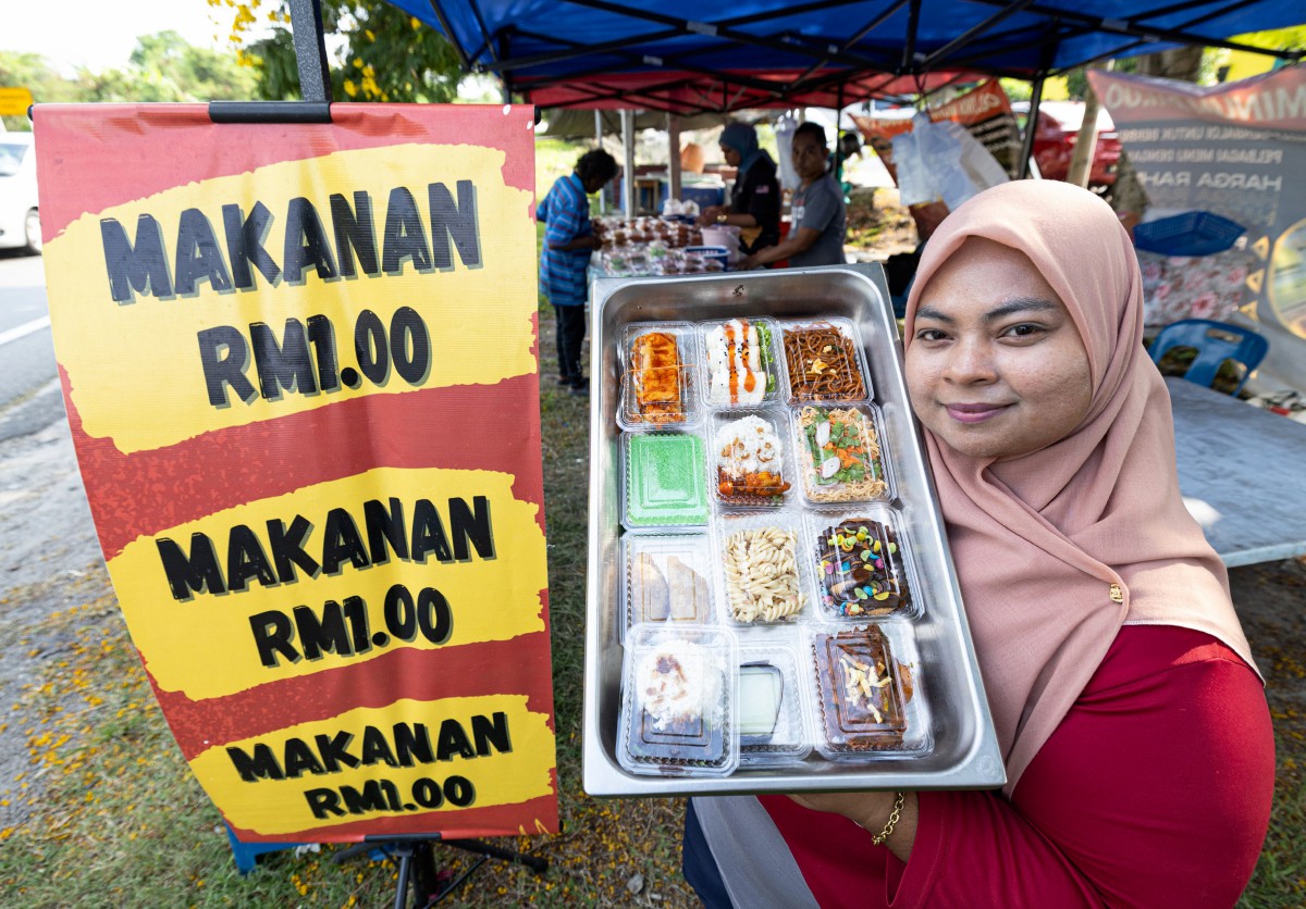 NURUL Nartisa menunjukkan antara makanan yang dijual dengan harga RM1 di gerainya di Klebang Jaya, Ipoh. FOTO Bernama.