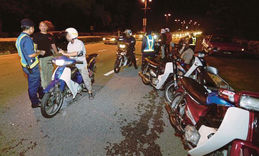 Anggota JPJ menjalankan pemeriksaan terhadap penunggang motosikal dalam Operasi Khas sempena Tahun Baru Cina.