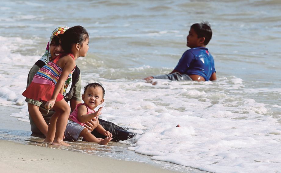Pengunjung bermain air di pantai Port Dickson, Negeri Sembilan walaupun ombak dijangka tinggi.