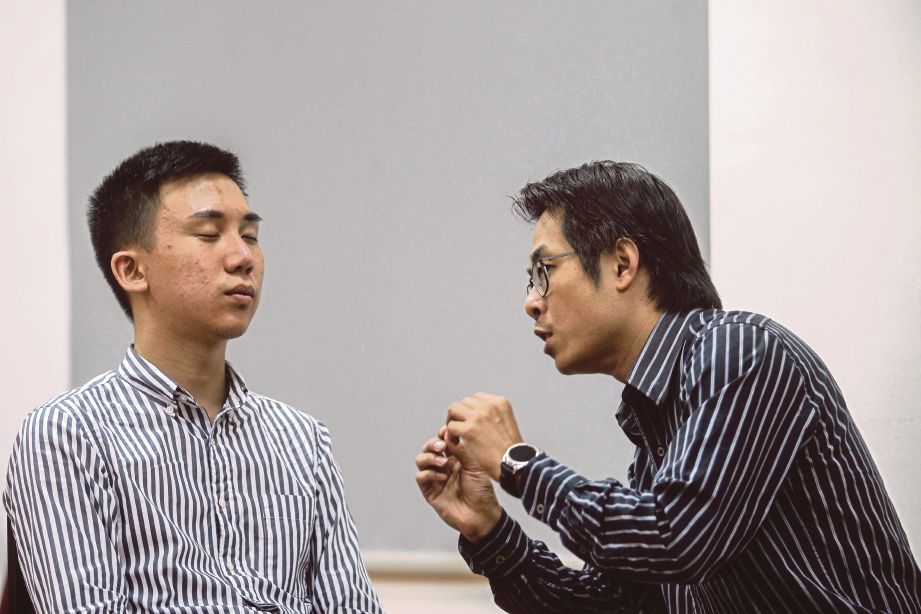 PENGAMAL hipnosis, Ting Wee (kanan) melakukan sesi hipnoterapi ke atas Derrick Chen.
