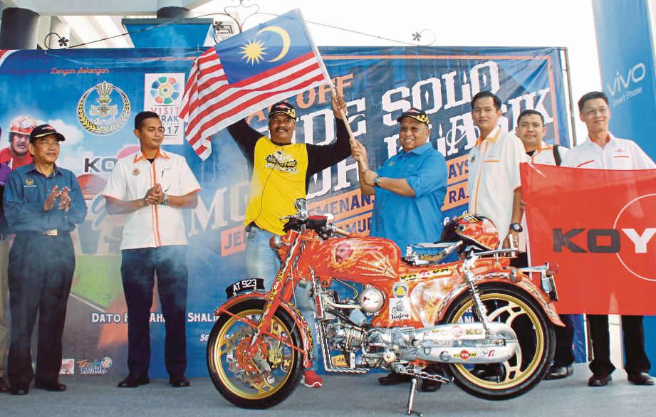 AHMAD (empat dari kanan) yang merasmikan Ride Solo Motor Klasik Jelajah Semenanjung Malaysia 2016  menyerahkan Jalur Gemilang kepada Kojeq (tiga dari kiri), semalam.