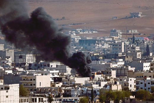 KEPULAN asap memenuhi ruang angkasa bandar Kobane selepas pakatan yang diketuai Amerika Syarikat melancarkan serangan udara, semalam. 