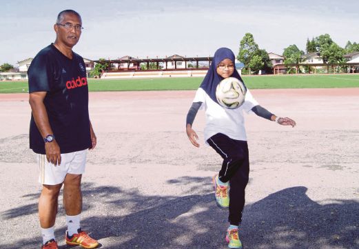 KHAIRUNISA memperagakan kemahiran menimbang bola disaksikan Mohd Nor.