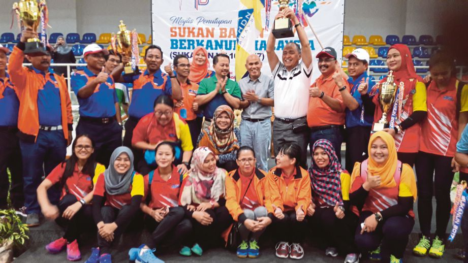 ABDULLAH (berdiri belakang, enam kanan) bersama kontinjen LHDNM yang muncul juara keseluruhan SUKANUN Malaysia.