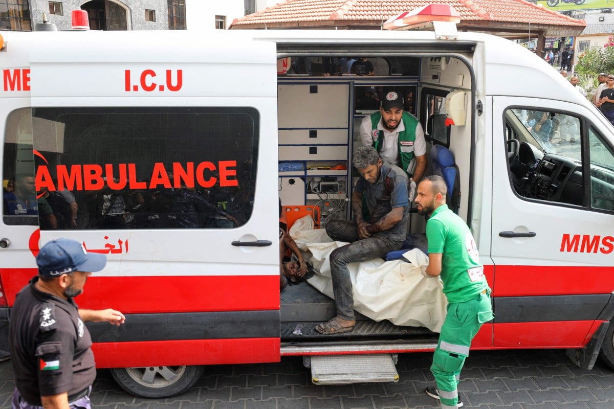 PETUGAS ambulans memberi rawatan awal sebelum memindahkan mangsa cedera ke Hospital Al-Shifa di Gaza. FOTO AFP.