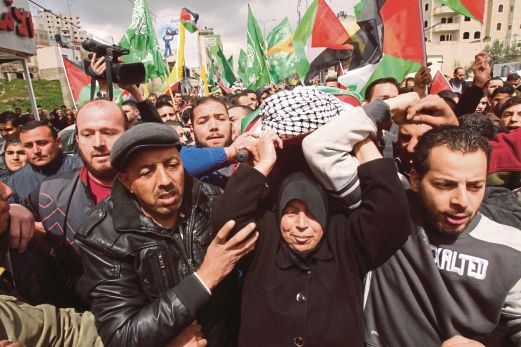 PENDUDUK Palestin, termasuk ibu mangsa kekejaman Israel, mengusung jenazah Amir Juneidi, yang ditembak mati selepas dituduh menyerang penduduk Israel, ketika pengebumiannya di bandar Hebron, Tebing Barat, semalam.  