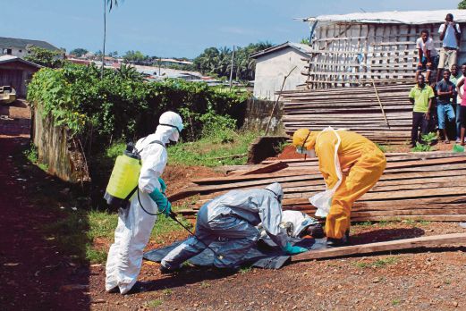 PEKERJA kesihatan mengangkat mayat seorang wanita yang mati akibat Ebola di daerah Aberdeen di Freetown, Sierra Leone, semalam. 