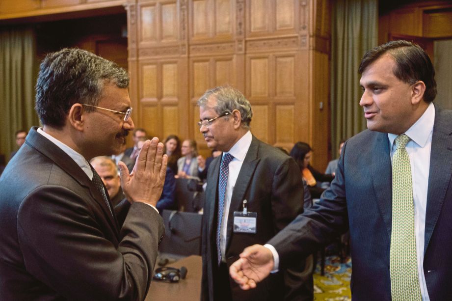 SETIAUSAHA Kementerian Luar Negara India, Deepak Mittal (kiri)dan wakil Pakistan, Syed Faraz Hussain Zaidi ketika mereka bertemudi mahkamah Dunia di The Hague, Belanda, semalam.  - AP 