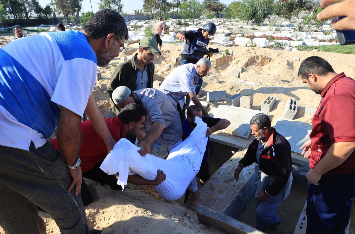 PENDUDUK Gaza mengangkat jenazah keluarga Zannoun yang meninggal dunia dalam serangan udara Israel. FOTO AFP.