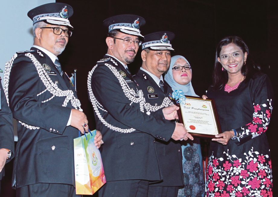  Mustafar   menyampaikan sijil penghargaan kepada  Kalidevi  pada Sambutan Hari Imigresen Malaysia, semalam.