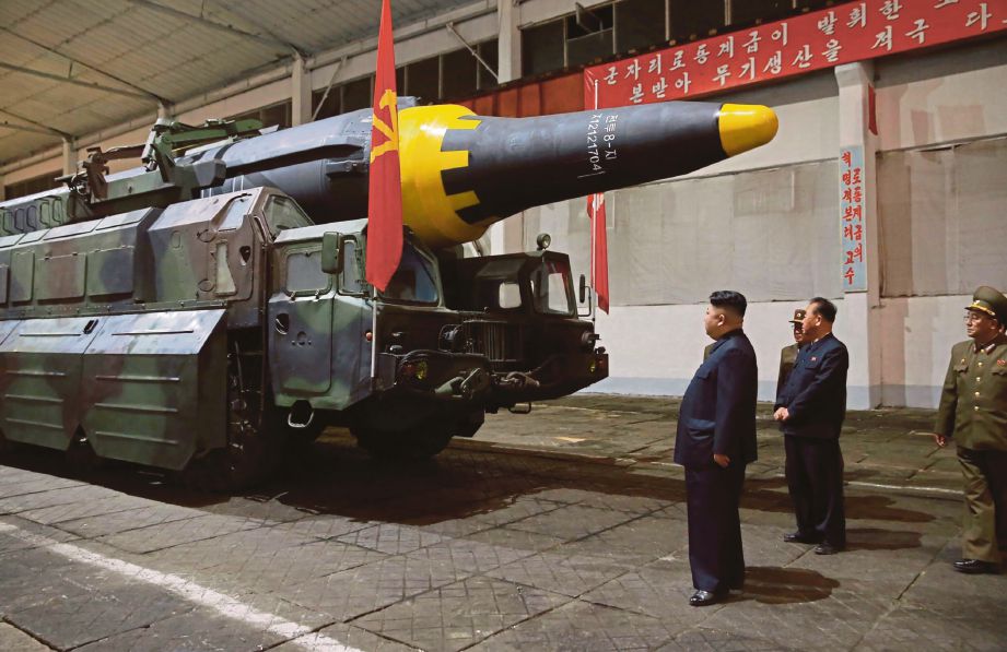 GAMBAR dirakam kelmarin menunjukkan pemimpin Korea Utara,  Kim Jong-Un (kiri) memeriksa misil jarak jauh di  lokasi yang dirahsiakan.  - AFP 