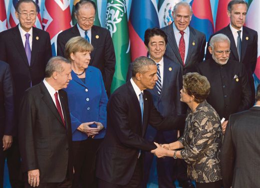 PRESIDEN Obama menyambut Presiden Brazil Dilma Rousseff sementara diperhatikan pemimpin lain ketika bersiap untuk bergambar bersama ketika sidang kemuncak G20 di Antalya, Turki, semalam.  