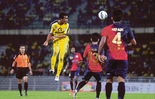 PEMAIN Perak, Ahmad Sukri Hamid (kiri) menanduk bola melepasi pemain PDRM.