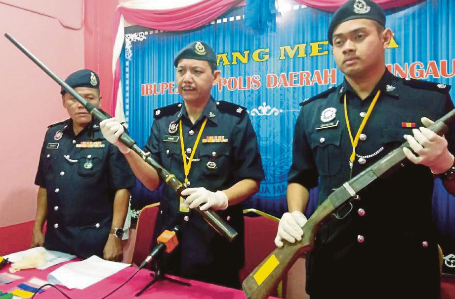  Ahmad  (tengah) menunjukkan senjata api dan peluru yang dirampas. 