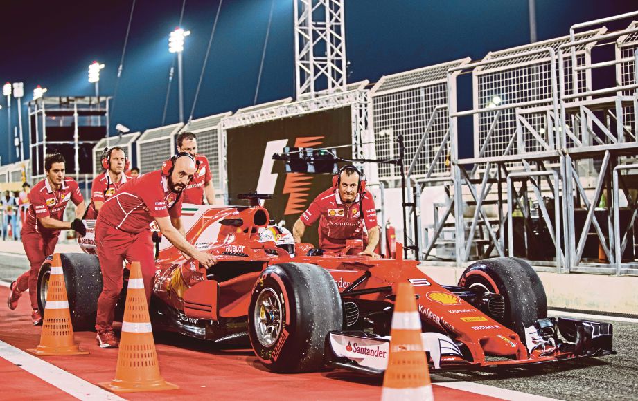 MEKANIK Ferrari menolak jentera dipandu Vettel selepas mengalami   litar pintas.