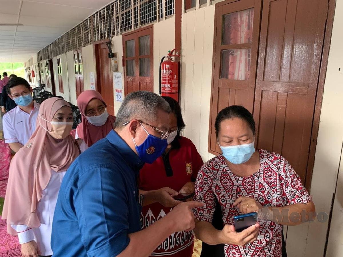 Dr Adham memberi panduan  vaksin kepada masyarakat di rumah panjang, Sarawak. FOTO IHSAN FB  Dr Adham Baba.