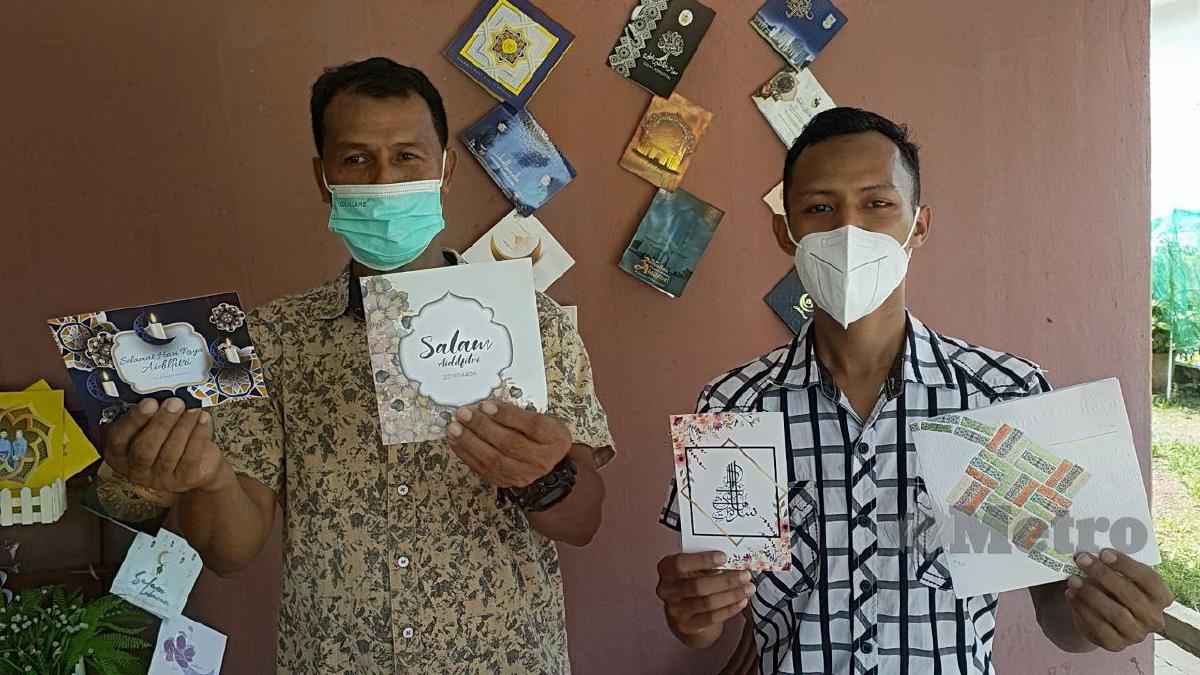 MUHAMMAD Azim (kanan) bersama Azizan menunjukkan kad ucapan hari raya yang dihantar kenalan mereka. FOTO Zuliaty Zulkiffli