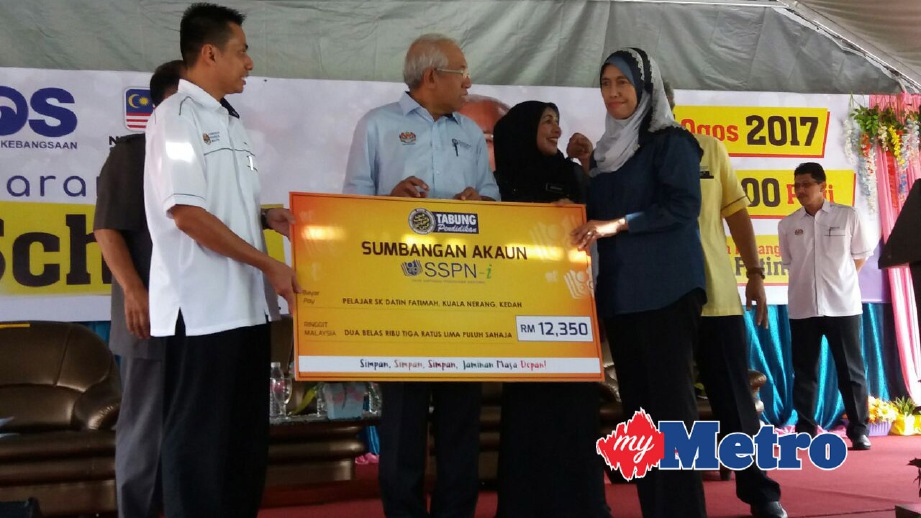 MAHDZIR menerima replika cek sumbangan kepada 240 pelajar SK Datin Fatimah bagi membolehkan mereka membuka akaun SSPN daripada Timbalan Ketua Eksekutif (Dasar & Operasi) Perbadanan Tabung Pendidikan Tinggi Nasional (PTPTN), Mastura Mohd Khalid. FOTO Muhaamad Hafis Nawawi