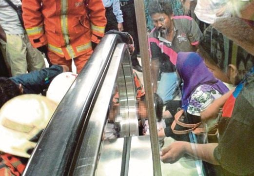 ANGGOTA bomba dan orang ramai  cuba membantu mengeluarkan jari kanak-kanak perempuan yang tersepit pada eskalator sebuah pasar raya besar di Ayer Keroh.