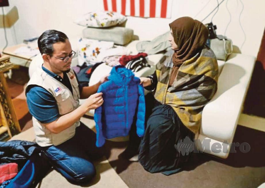 AMINAH menerima sumbangan baju sejuk dari wakil Muslim Care, Dr Syariz Izry Sehat di Pejabat Muslim Care Turki.