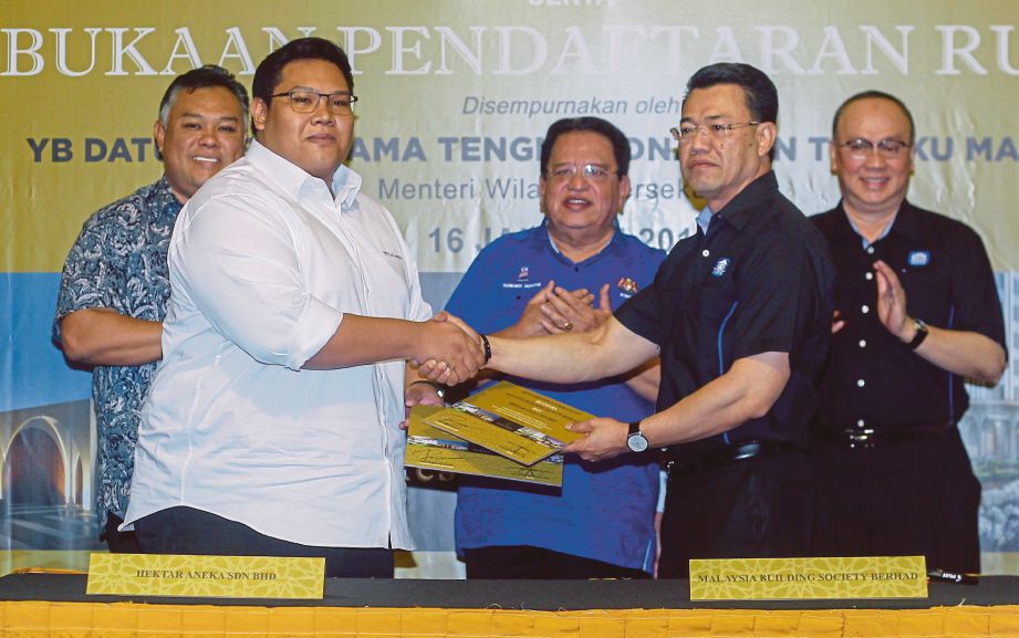 TENGKU Adnan (tengah) menyaksikan pertukaran dokumen perjanjian antara Rozabil (kiri) dengan Naib Presiden Kanan Bahagian Perniagaan Korporat MBSB Datuk Nor Azam M Talib   di Kuala Lumpur, semalam.