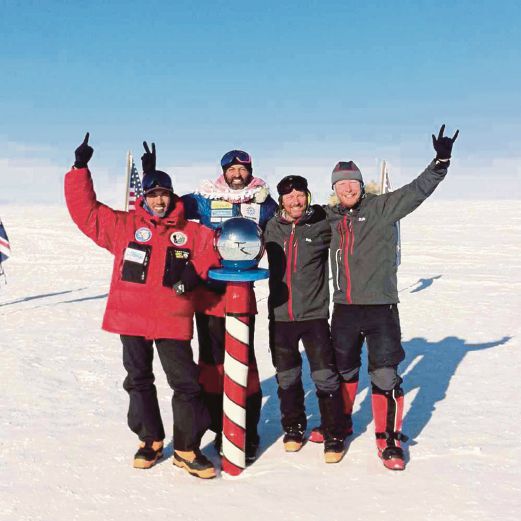 SHAHROM (kiri) bersama rakan penjelajah bergambar di titik sifar Kutub Selatan.