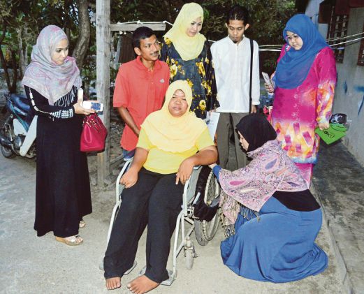 Noorulhuda (kanan) memasang pelapik tayar kerusi roda 'Kasoot WheelChair' Siti Aminah.
