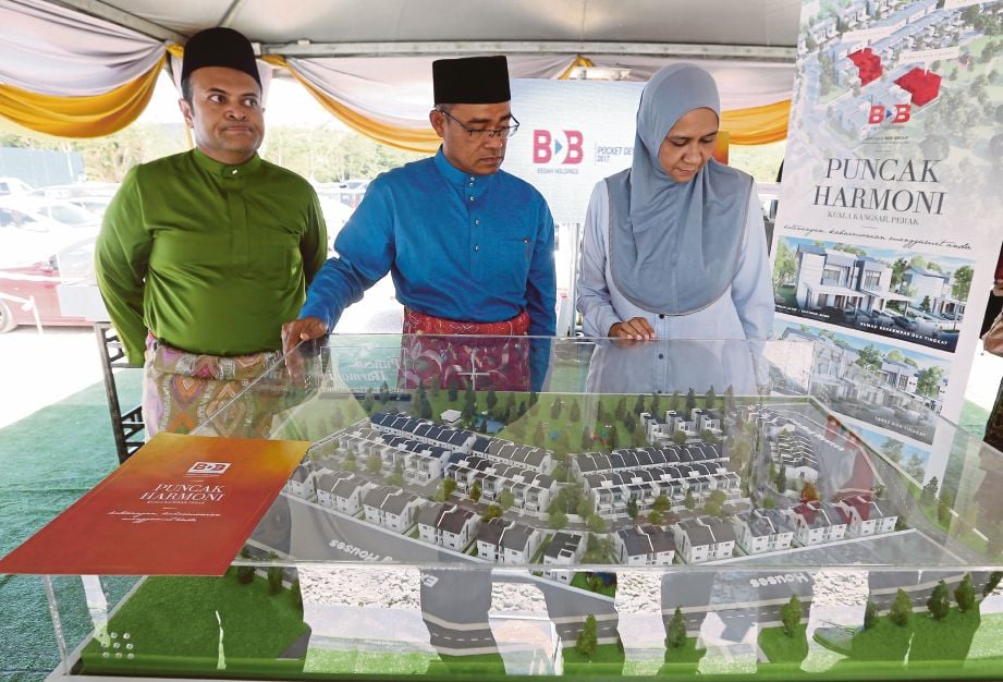 IZHAM (tengah) dan Mastura melihat model rumah yang ditawarkan KHSB melalui Projek Perumahan Puncak Harmoni di Kuala Kangsar.