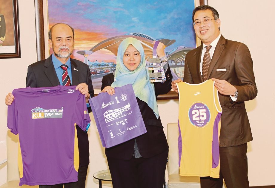 ZAINOL (kiri) bersama Ketua Kejuruteraan Malaysia Airports (Sepang) Sdn Bhd, Nor Azlina Mohd Isa dan Pengurus Besar Hotel Sama-Sama Kuala Lumpur International Airport, Norazzudin Omar menunjukkan baju dan medal KUL Marathon 2017. 
