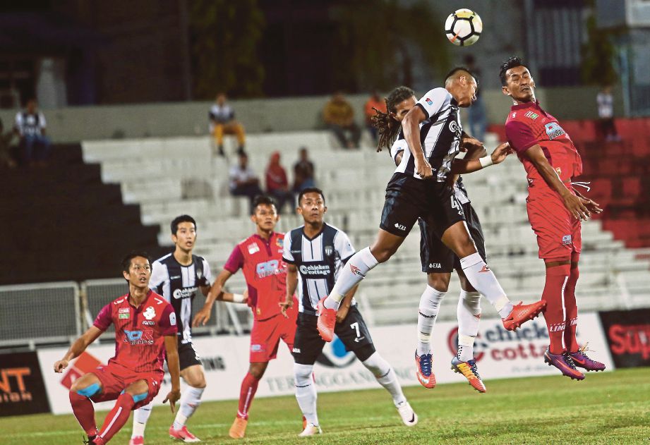 PEMAIN Terengganu FC II, Radhi Mohd Yusof (dua kanan) menanduk bola di hadapan pintu gol pasukan PDRM pada perlawanan Liga Perdana di Stadium Sultan Ismail Nasiruddin Shah.