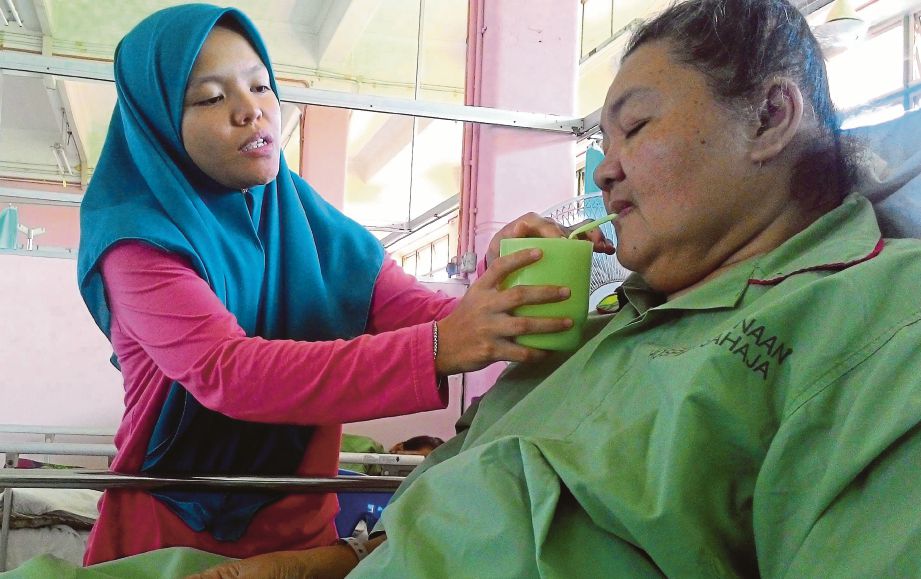  Nornadirah menjaga Norila  yang baru selesai menjalani pembedahan membuang kaki kanan akibat penyakit kencing manis di Hospital Melaka.
