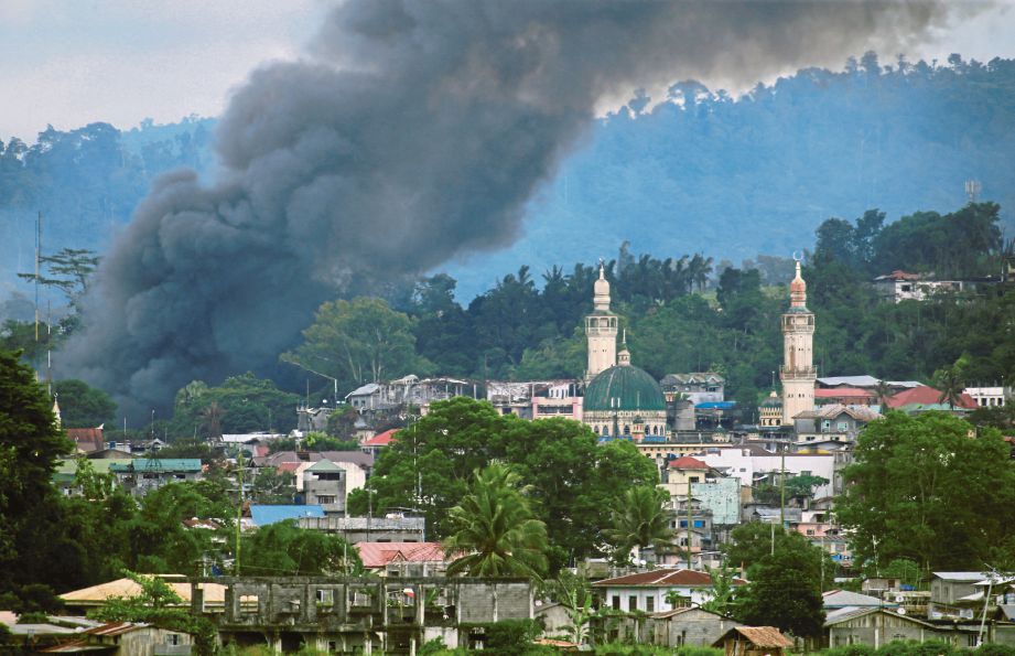 KEPULAN asap memenuhi ruang udara di Marawi selepas kawasan yang dipercayai menjadi tempat persembunyian militan dibom, semalam.  - Agensi 