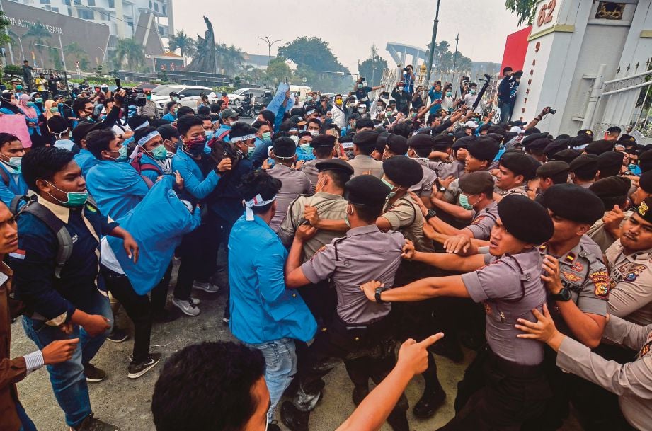 POLIS bertempur dengan pelajar yang berhimpun di pejabat gabenor  Riau di Pekanbaru bagi mendesak kerajaan bertindak tegas memadamkan kebakaran hutan yang menjadi punca jerebu teruk. FOTO AFP