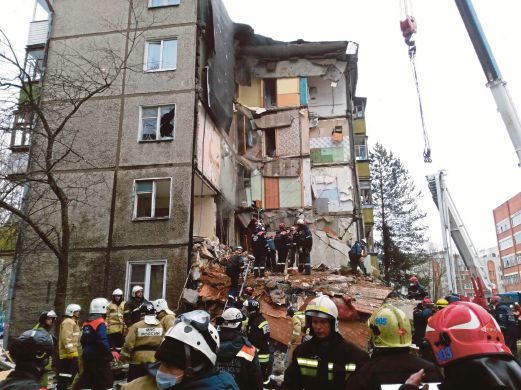 PASUKAN penyelamat berusaha mengeluarkan mangsa dari runtuhan bangunan.