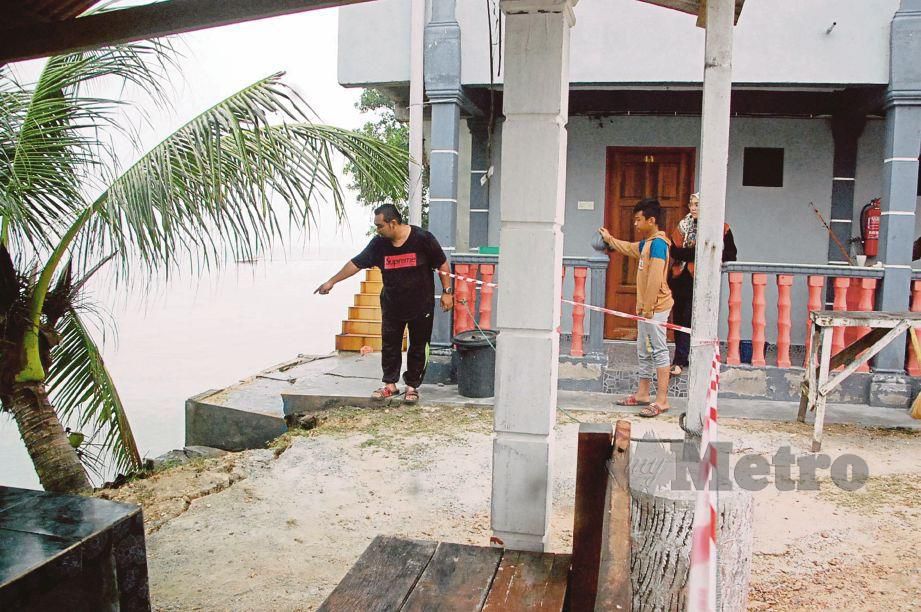 AZIZAN menunjukkan lantai di kaki lima yang merekah akibat hakisan pantai di Chalet Keluarga Seri Pelangi, Kampung Sungai Kertah, Pengkalan Balak, Masjid Tanah.