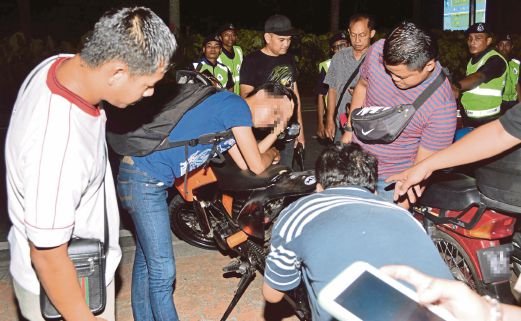  PENUNGGANG motosikal yang ditahan kerana cuba melarikan diri daripada sekatan jalan raya ketika Operasi Bersepadu Cegah Jenayah dan Samseng Jalanan di Shah Alam.