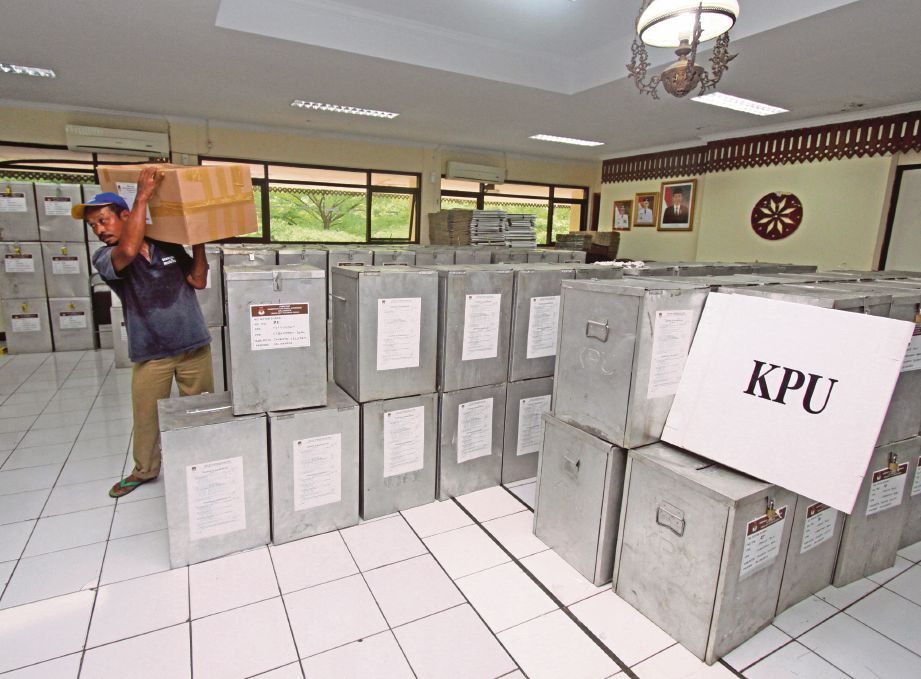 SEORANG petugas menyusun kotak undi menjelang pilihan raya pusingan kedua gabenor Jakarta di satu lokasi di Jakarta kelmarin. - Antara