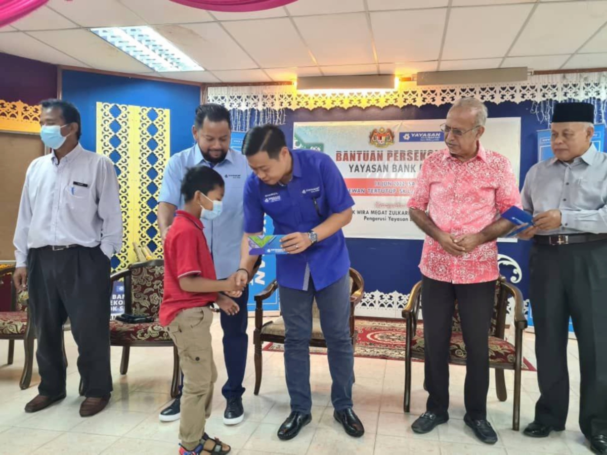 MOHD Shahrizal (tiga kiri) menyampaikan bantuan kepada murid. FOTO ihsan YBR