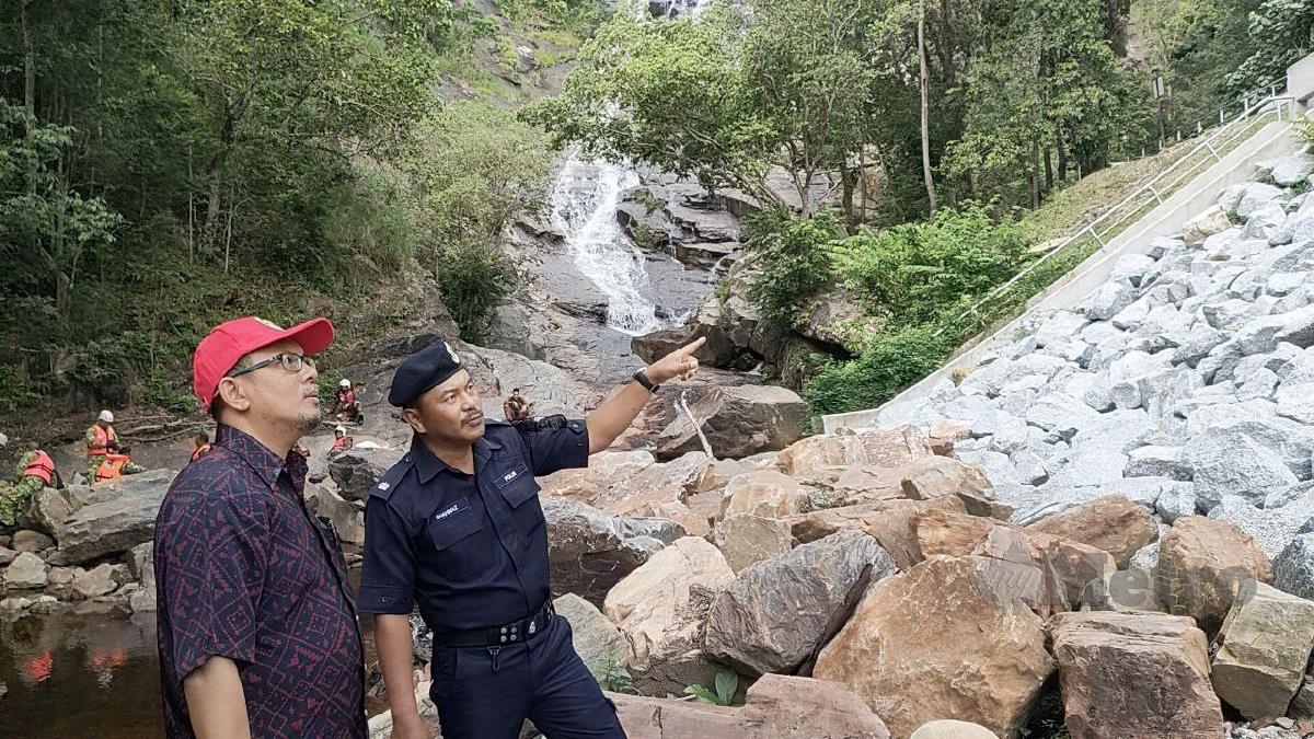 MOHAMAD Subhi (kiri) dan Shahnaz meninjau kawasan air terjun Seri Perigi yang berlakunya kepala air tahun lalu. FOTO Zuliaty Zulkiffli