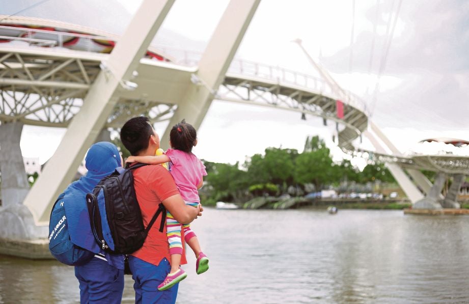 PELANCONG  menyaksikan Jambatan Darul Hana yang merupakan ikon terbaru di bandaraya Kuching.