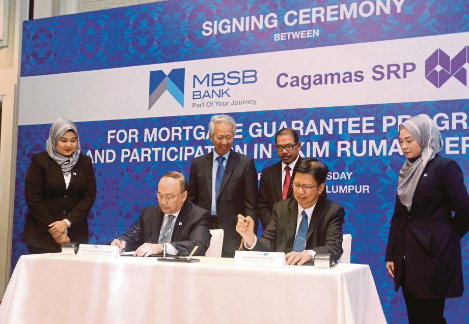 AHMAD Zaini (dua dari kiri) bersama Chung  menandatangani perjanjian kerjasama dua hala bagi MGP Cagamas dan penyertaan MBSB menerusi Skim Rumah Pertamaku di Kuala Lumpur, semalam.