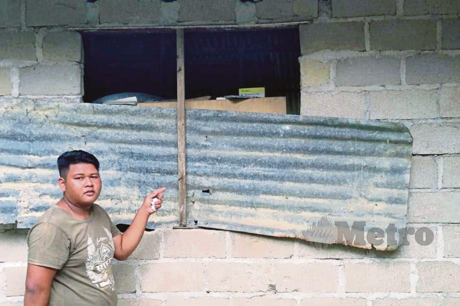 MOHAMAD Syahadam menunjukkan rumah pusaka yang daif dengan jendela ditutup menggunakan zink. FOTO Ramli Ibrahim