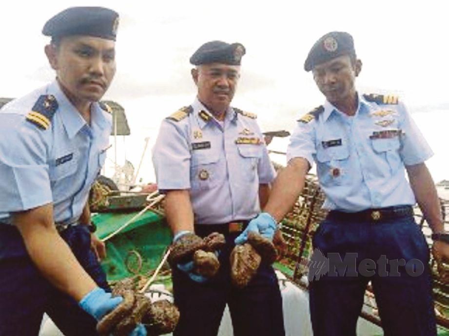 MUHAMMAd Suffi  (tengah) menunjukkan gamat yang dirampas daripada sebuah bot nelayan Vietnam. 