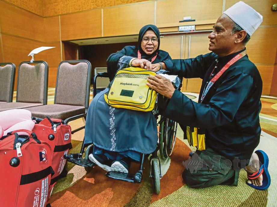 ABU Hassan membantu mengemas beg isterinya, Raemah di Kompleks Tabung Haji KLIA. 