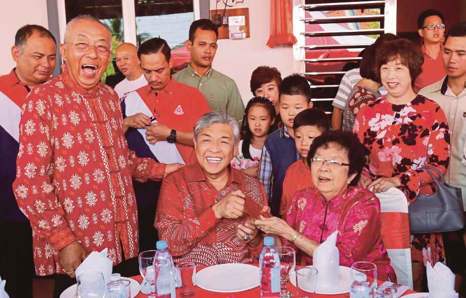 Ahmad Zahid  menyampaikan angpau kepada Cheah Siok Liang, 77, ketika berkunjung di kediaman Beh Song Wan sempena sambutan Tahun Baru Cina di Taman Desa Bersatu, Hutan Melintang. 