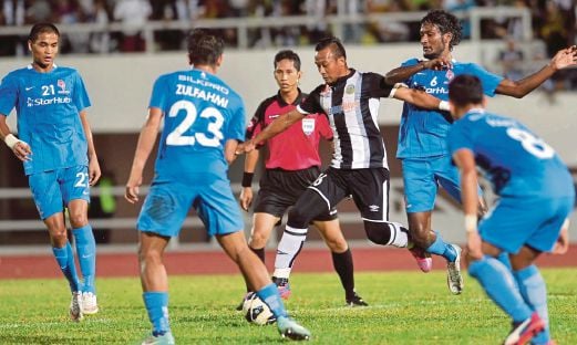 PEMAIN Terengganu Mohd Zubir Azmi (tengah) cuba melepasi kawalan empat pemain LionsXII pada perlawanan di Stadium Sultan Mizan Zainal Abidin.