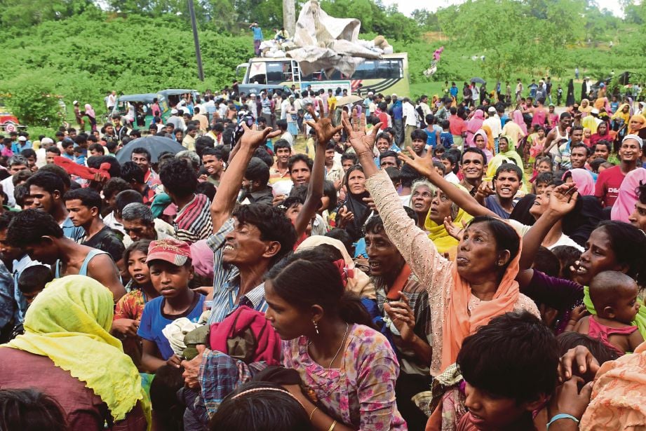 PELARIAN Rohingya berebut ketika menerima sumbangan.