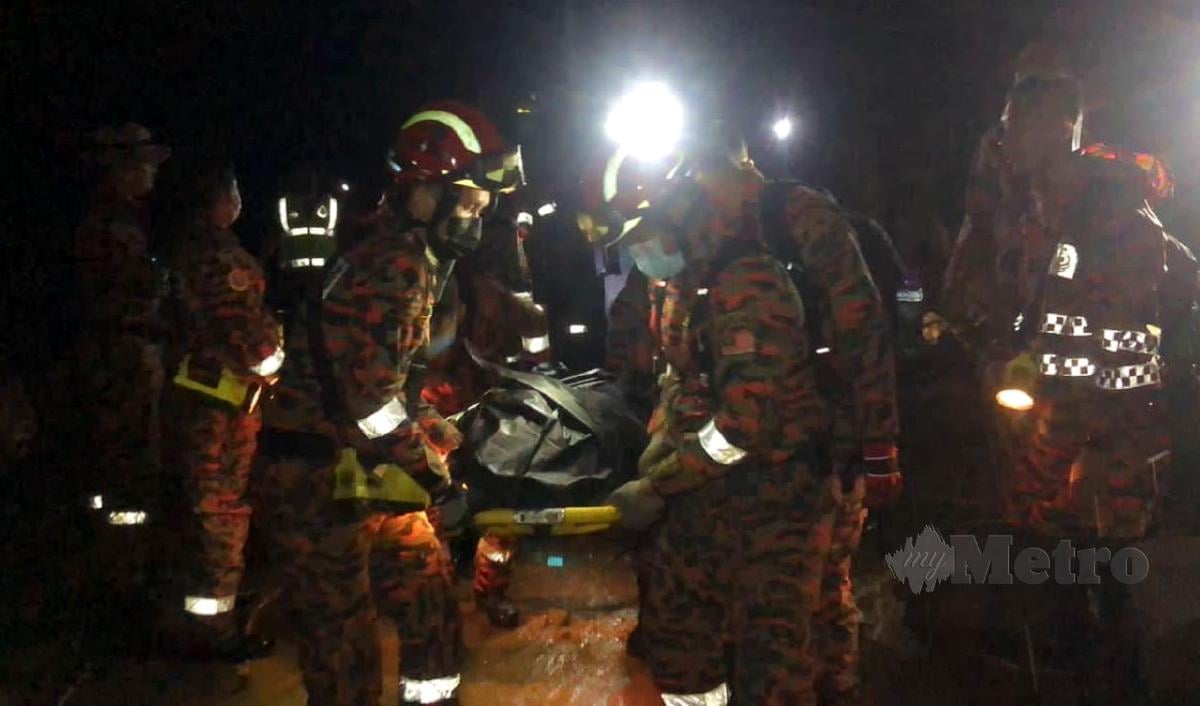 ANGGOTA bomba mengangkat mayat pekerja Jerai Hill Resort yang maut akibat fenomena kepala air di puncak Gunung Jerai. FOTO Zuliaty Zulkiffli.