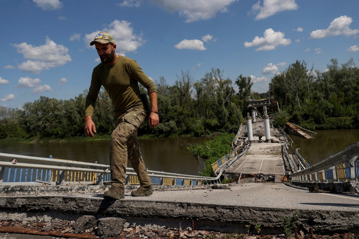 PETUGAS perkhidmatan Ukraine melalui jambatan di sungai Siverskyi Donets yang musnah akibat serangan Rusia di perkampungan Bohorodychne, wilayah Donetsk, semalam. FOTO Reuters.
